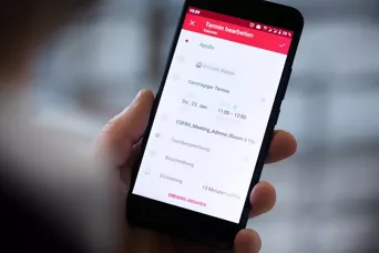 Handy mit geöffneter Terminreservierungsapp