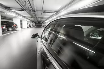 Auto fährt durch beleuchtetes Parkhaus