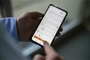 Person nutzt eine Smartphone-App zur Steuerung einer Steinel Leuchte mit individuellen Einstellungen.