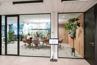 Ein besetzter Meetingraum mit eingeschaltetem Licht