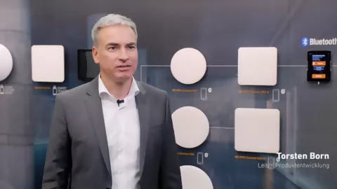 Thorsten Born, Leiter Entwicklung bei STEINEL vor einem Panel mit Leuchten