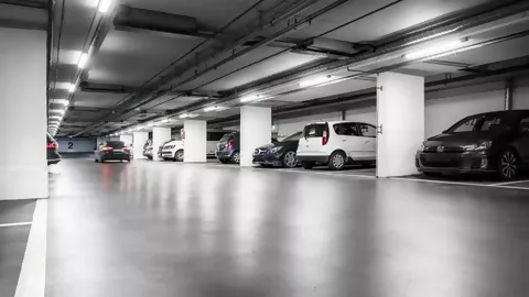 Beleuchtetes Parkhaus in dem Autos parken