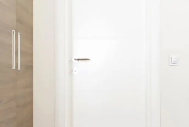 White door next to which the IR 180 motion detector from STEINEL is installed.